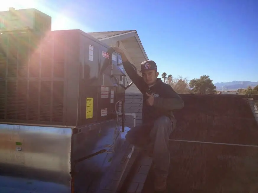 HVAC technician performing HVAC Inspection on a rooftop unit in Minooka